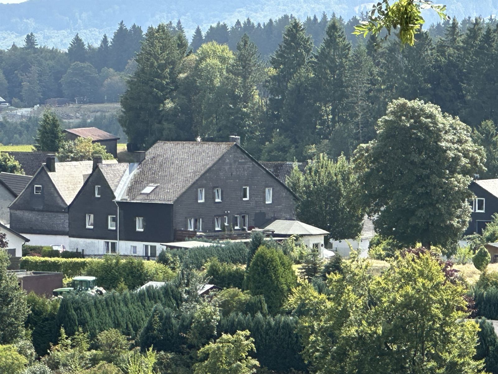 Summer view over the village, meadows and wooded hills